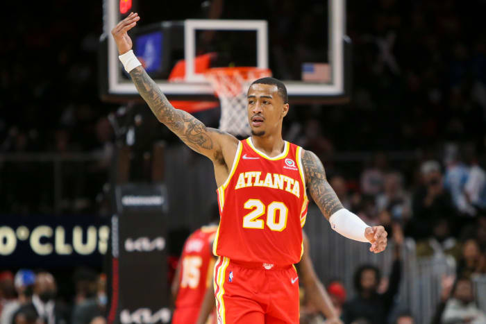 John Collins waves to the fans during a game.